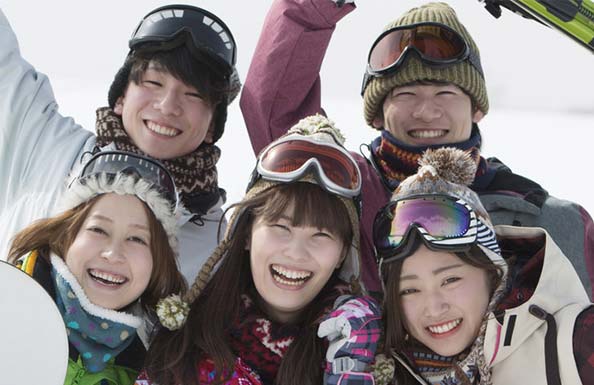 笑顔で映るスノーボーダー３人組の男女