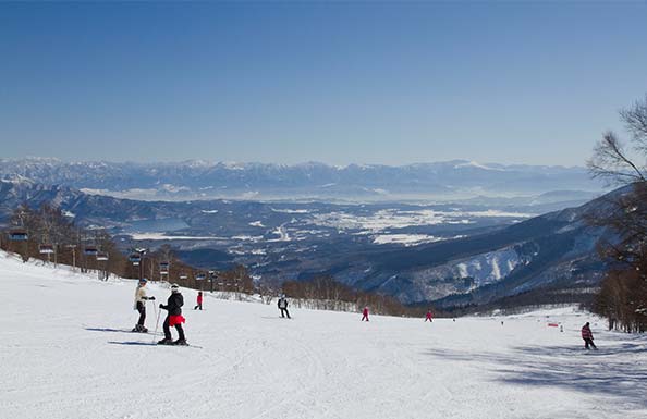 ゲレンデでスノーボードをする人々